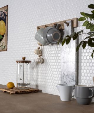 white circular textured mosaic tile backsplash with kitchen utensils and accessories