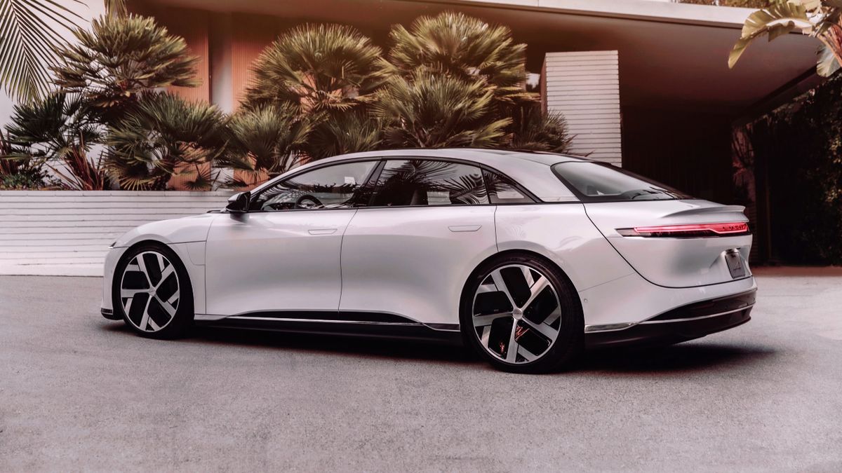 Side profile of the Lucid Air EV parked outside a modern house