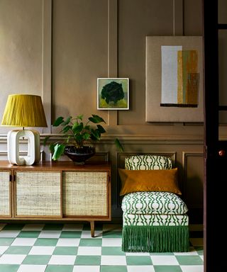 hall with green checkerboard tiled floor, sideboard and green upholstered chair