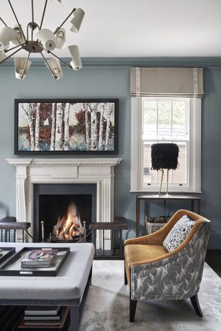 Light blue living room with fireplace andorang armchair