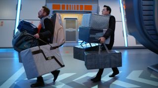 The Orville crew moving heavy bags out of a spaceship.