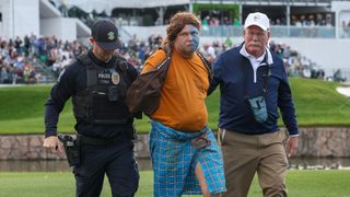A fan at the Phoenix Open is apprehended by a police officer