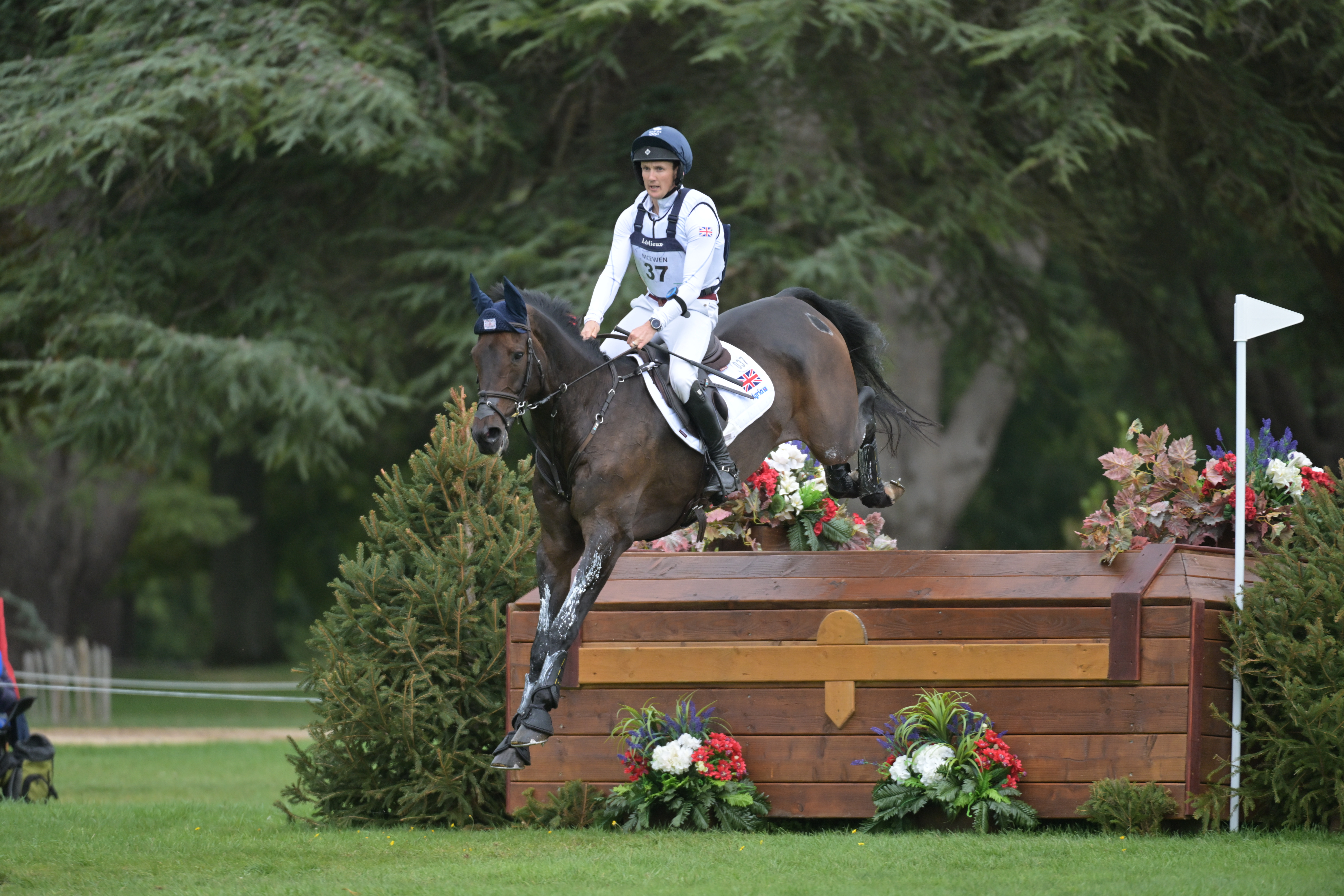Tom McEwen and JL Dublin jump a large wooden box fence at the 2025 Blenheim European Eventing Championships. 