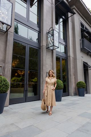 Woman wearing a midi dress with slide sandals.