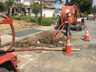 Pulling the conduit back through the ground.