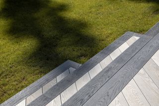 Grey decking steps leading down onto a green lawn