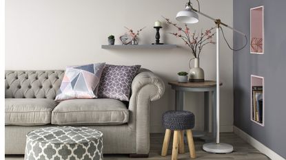 Living room with sofa, floor lamp, footstool and accessories