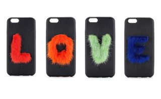 Four black cellphone covers with a furry coloured letter on each spelling the word "LOVE".