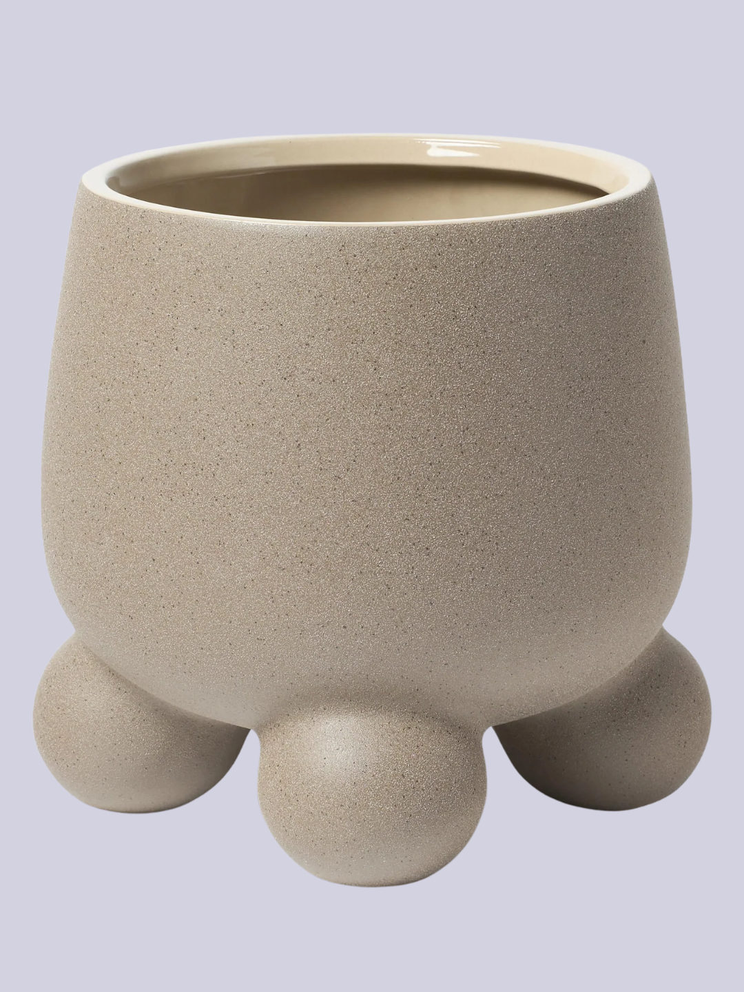 A speckled beige planter with three round feet