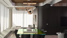 modern open plan dining and living room with cork ceiling, sheer curtains, curved walls, statement pendant lights, green glass table
