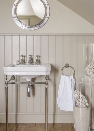white bathroom with white sink and round mirror