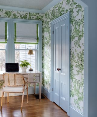 office nook with green and white floral wallpaper and light blue woodwork, trim and cupboard doors