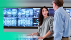 Woman and man in front of large display screen