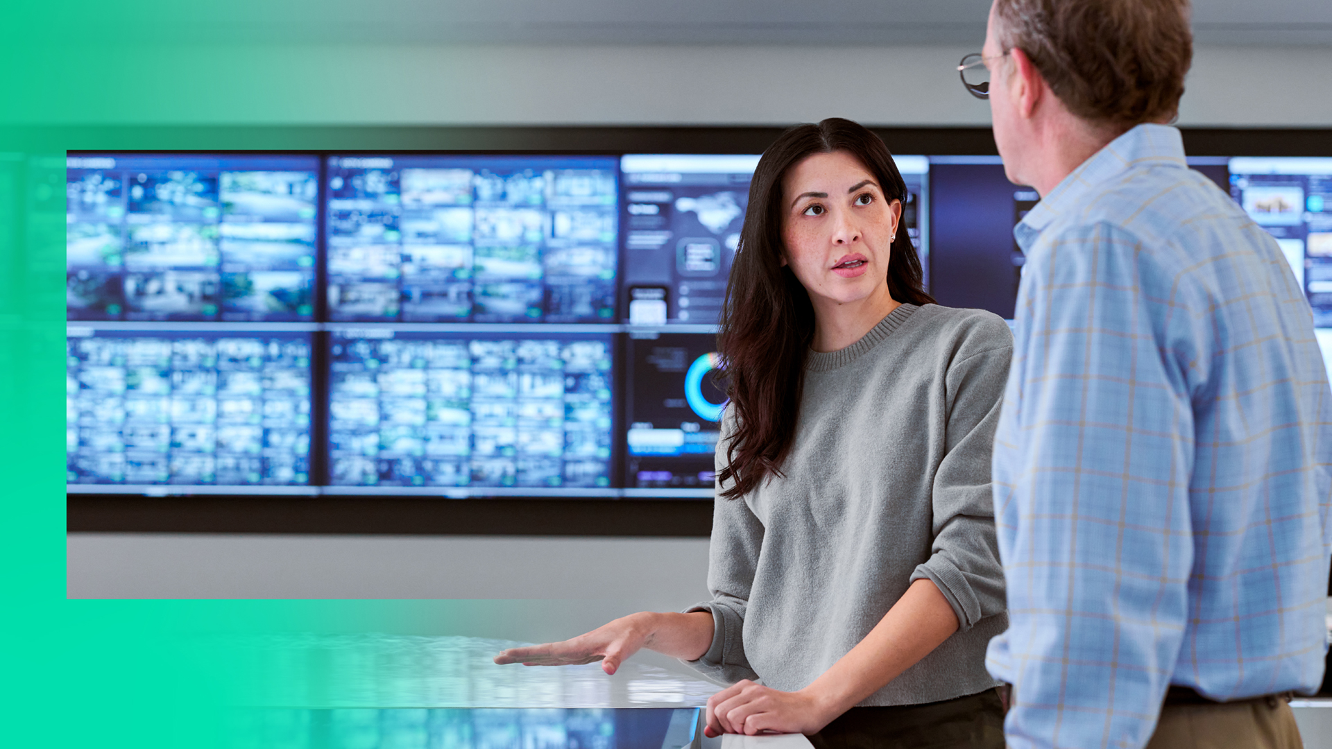Woman and man in front of large display screen