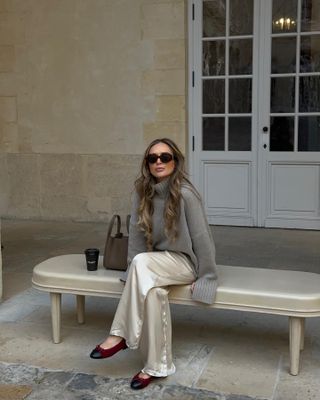 Olivia wears a soft knit and Arket silk trousers