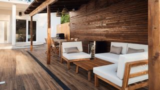 Patio with wood effect floor, contemporary real wood porch with barbeque and furniture in foreground