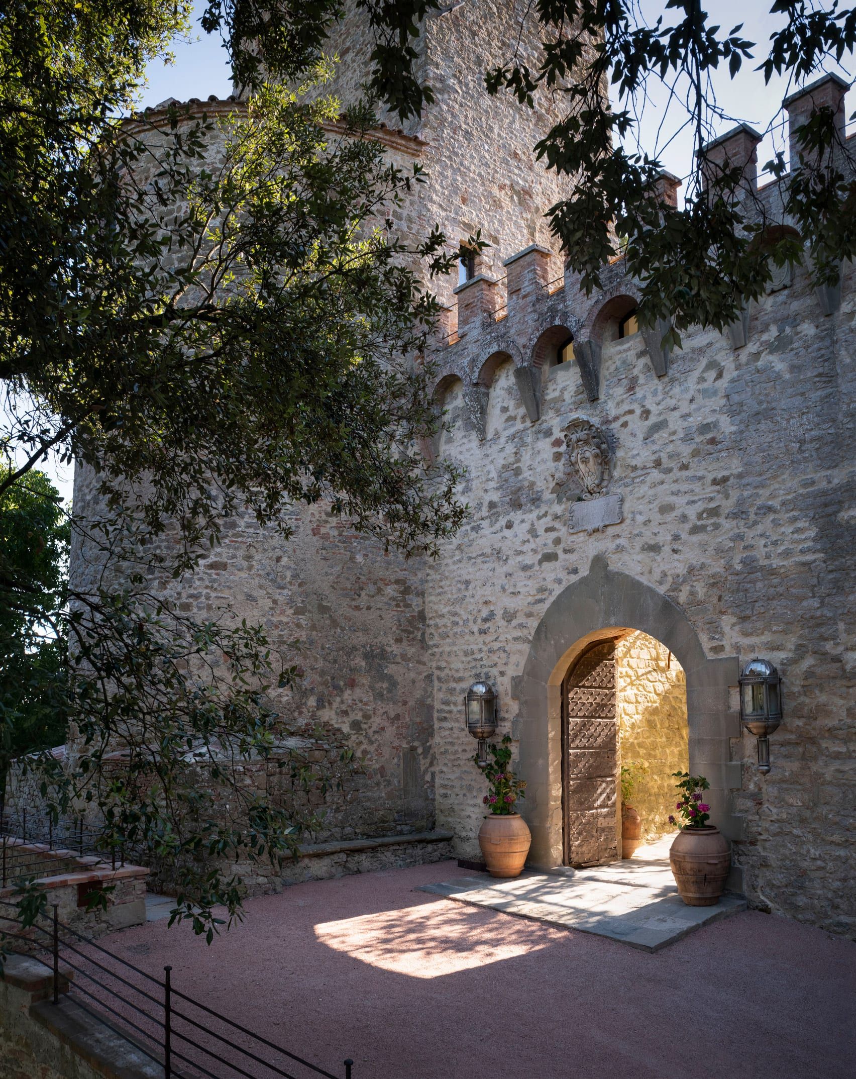 A series of images depicting the palatial interiors and leafy, sun-filled exterior of a castle revived as a contemporary design holiday destination.