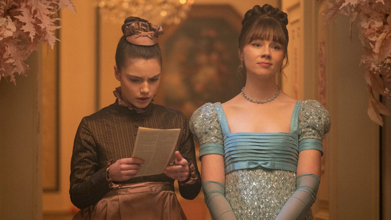 Hyacinth looking down at a copy of Lady Whistledown while Eloise looks off into the distance. 