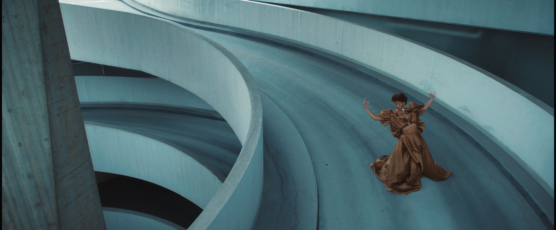 A woman slipping down a curved, concrete structure
