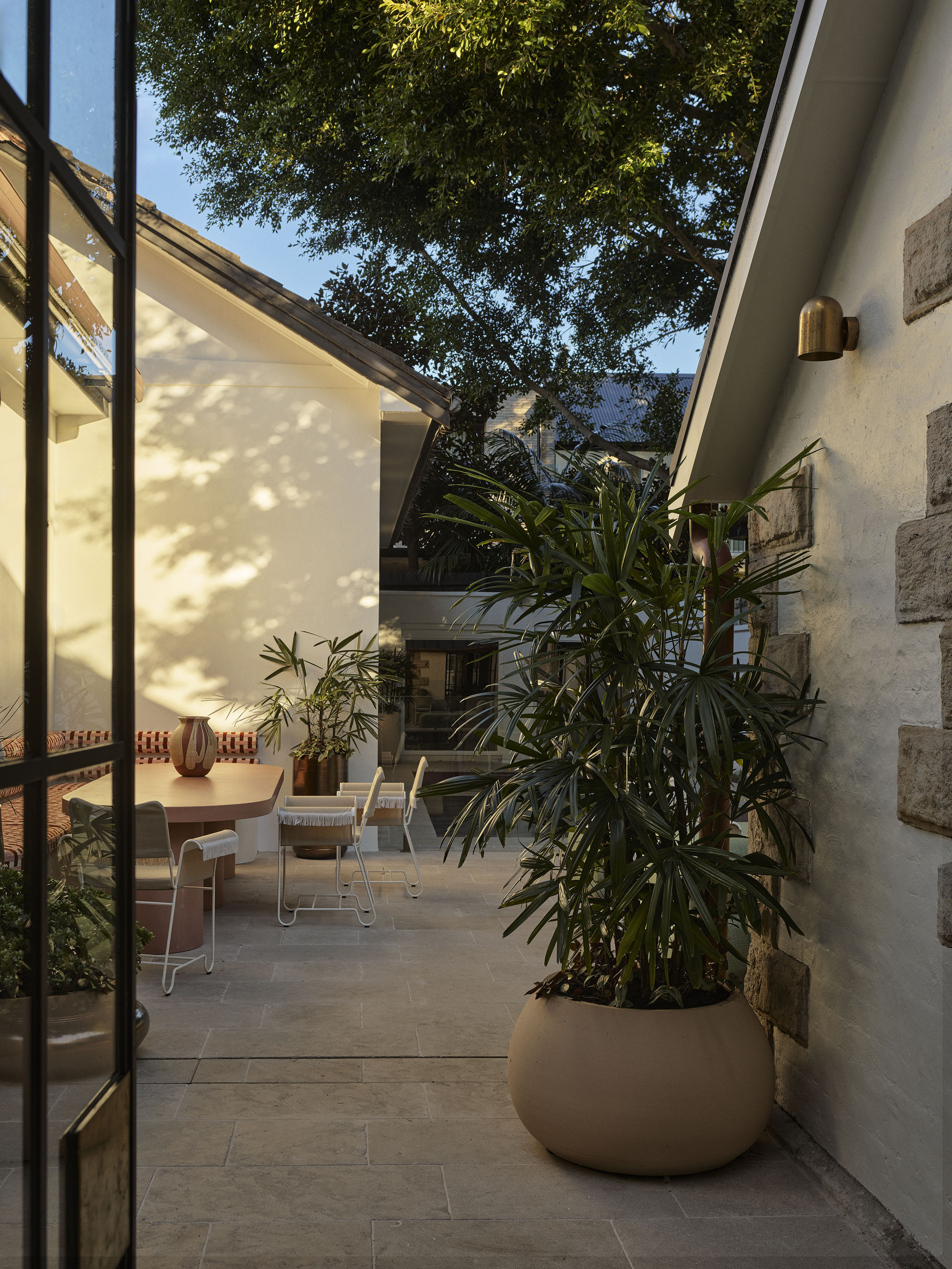 a sunny outdoor courtyard with a banquette dining area