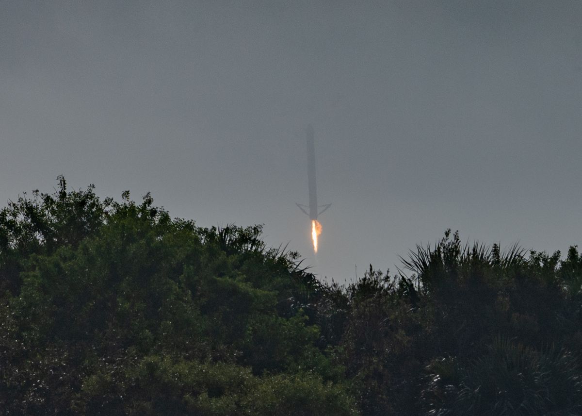 One of the Falcon Heavy's two side boosters comes down for a landing at Cape Canaveral Space Force Station during the USSF-44 mission on Nov. 1, 2022.