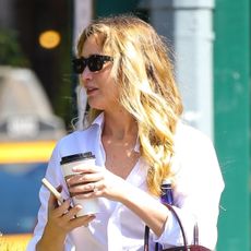 Jennifer Lawrence wearing a white button-down, jeans, black flats, and a burgundy croc-embossed bag in NYC