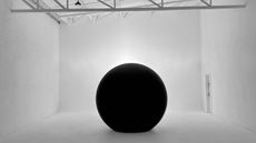 A sphere-like Xydrobe portal in a plain white room