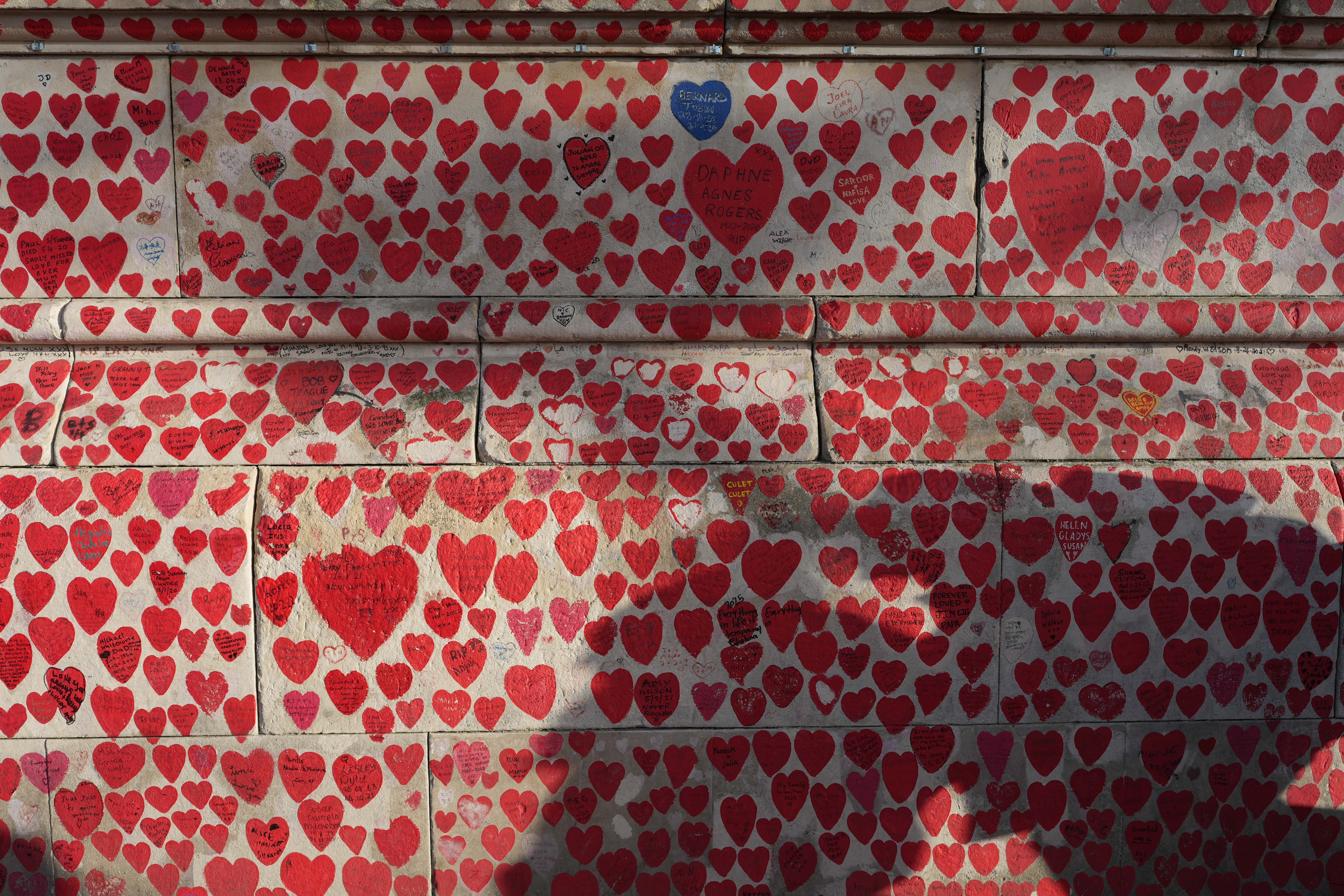 A mural of hundreds of hearts painted on a wall