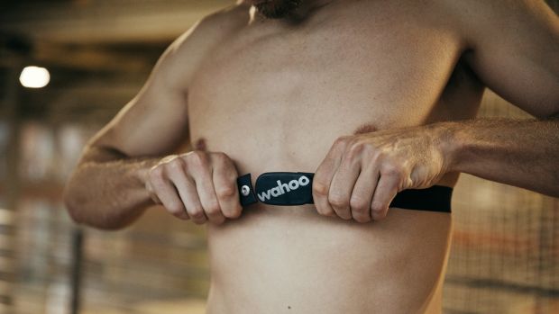 Man straps on Wahoo TICKR chest strap heart rate monitor