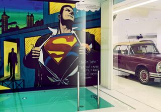 Indoor pool with a Superman mural by Kron Designs, and a marble garage housing a vintage 1971 Mercedes 280SE 3.5