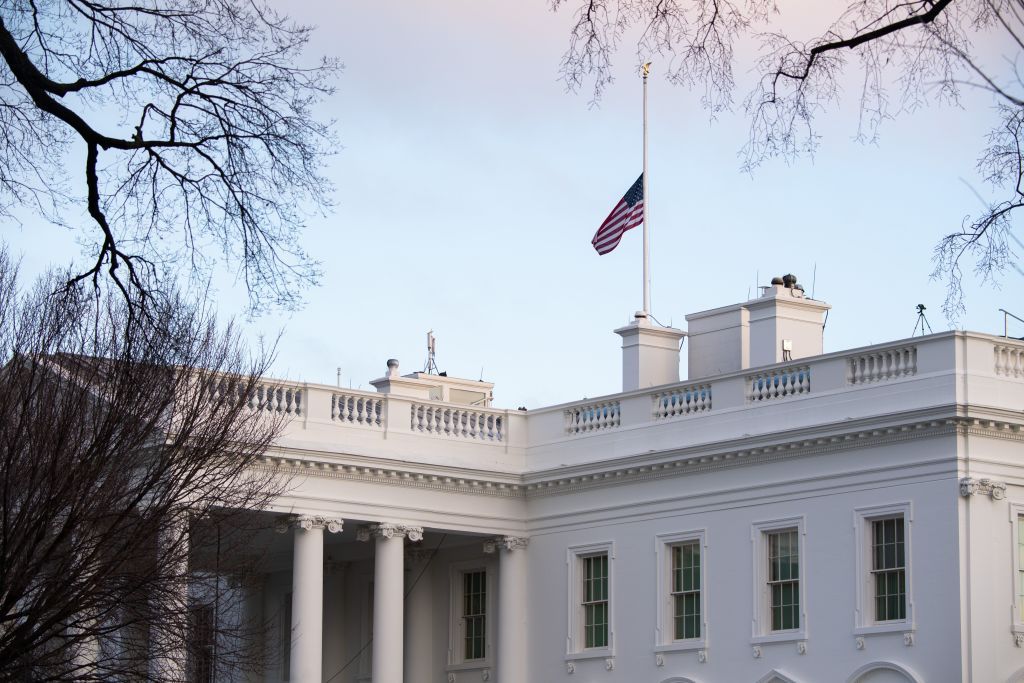 Flag flying half staff over White House.