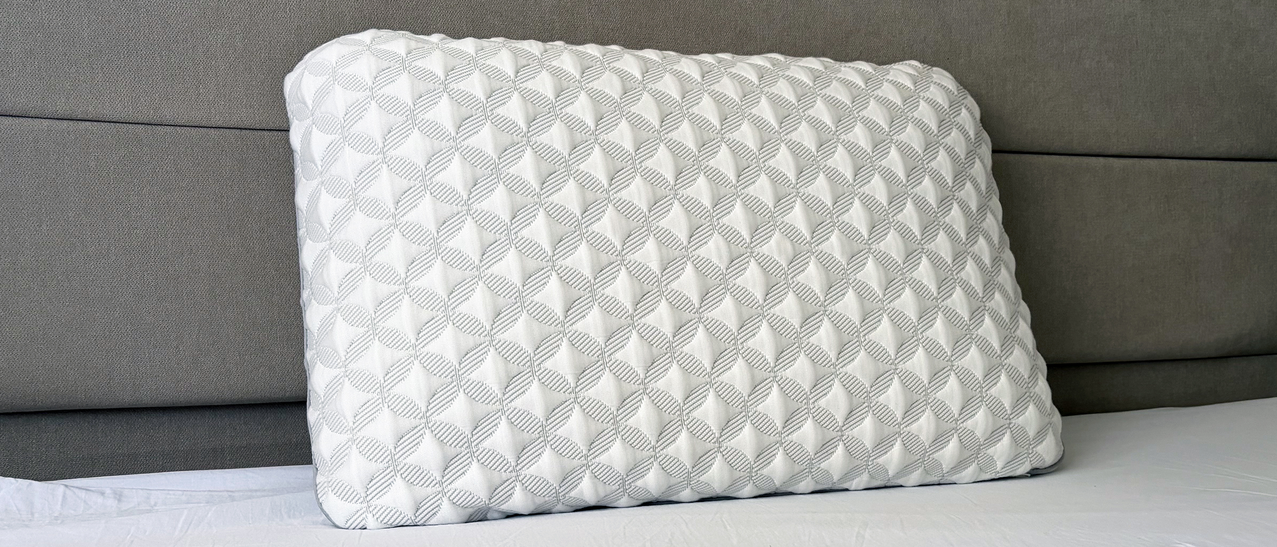 A close up of the Helix Talalay Latex pillow resting against the headboard in our reviewer's bedroom