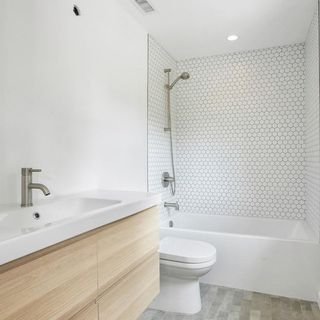 bathroom with white wall sink and commode