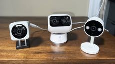 Eufy Tapo and Wyze security cameras lined up on a table