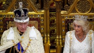 Britain's King Charles III, wearing the Imperial State Crown and the Robe of State, sits beside Britain's Queen Camilla, wearing the George IV State Diadem, as he reads the King's speech from The Sovereign's Throne in the House of Lords chamber, during the State Opening of Parliament, at the Houses of Parliament, in London, on November 7, 2023. 