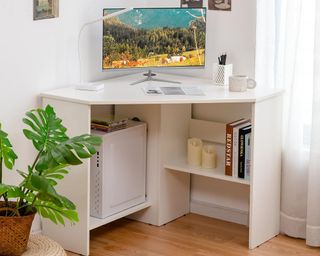White corner desk with computer and books