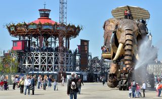 Fleet of giant mechanical creature next to a carousel