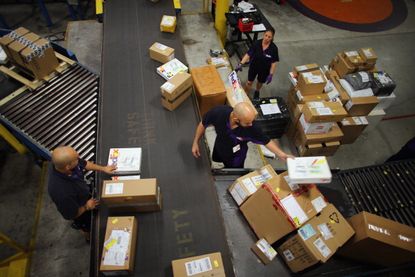 FedEx employees sort through items.