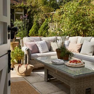 cottage paved patio area with outdoor corner sofa and coffee table