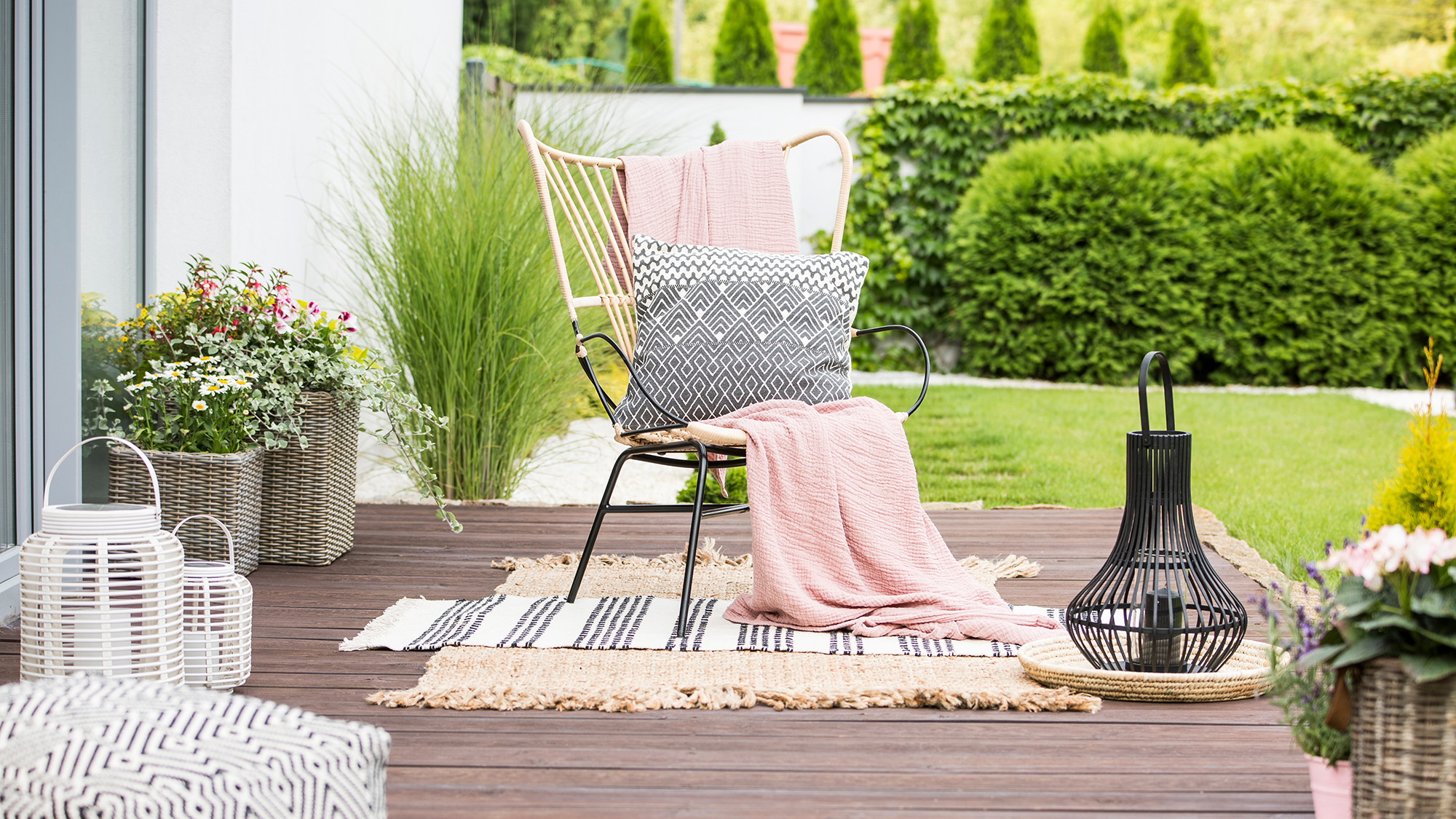 Outdoor patio area with decorative throws, cushions and rugs