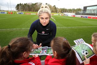 Houghton signs autographs during a training session at St George’s Park (Nigel French/PA).