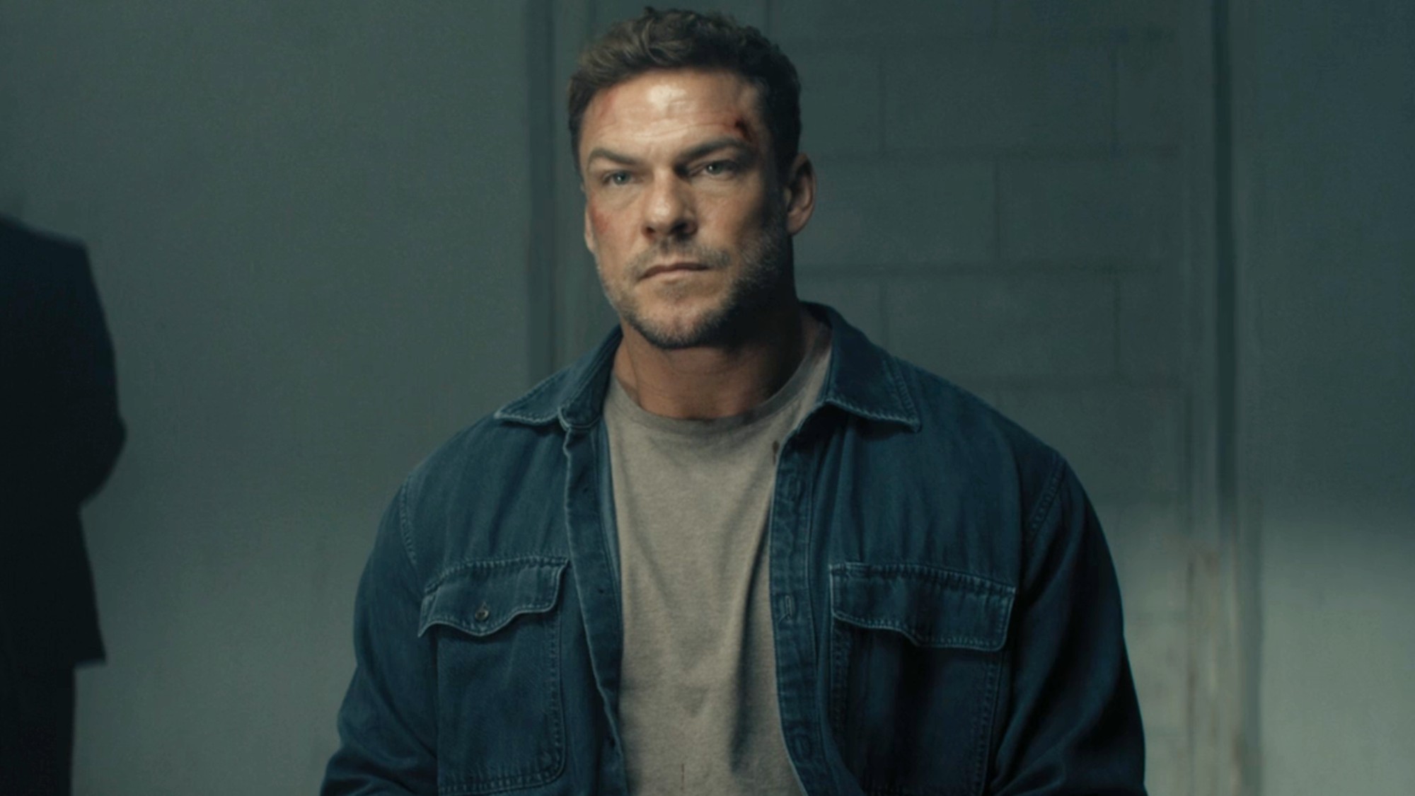 Alan Ritchson as Jack Reacher sitting inside in Season 4 of Reacher. 