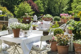 cottage garden layout ideas: seating surrounded with terracotta pots