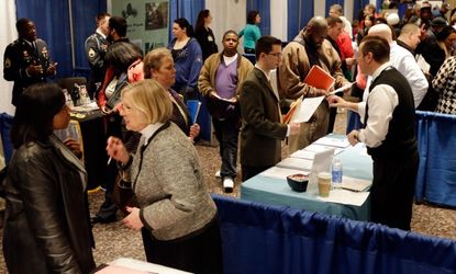 Job-seekers talk to business representatives during a career fair in Albany, N.Y., on April 11.