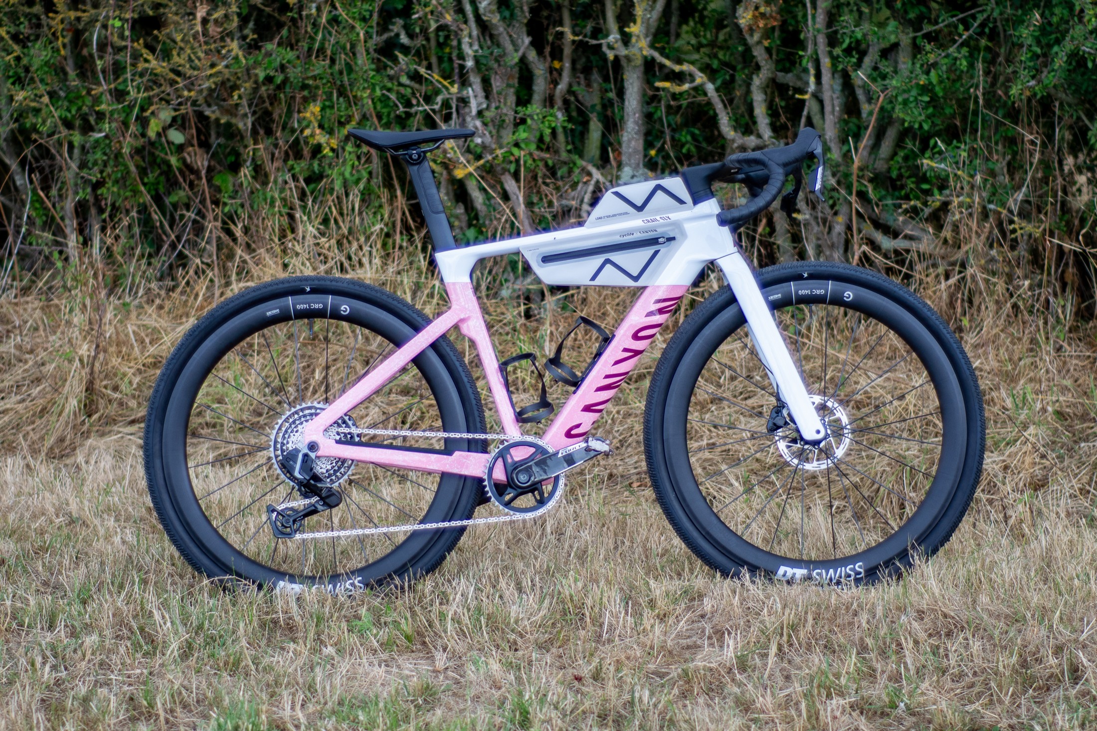 A pink and white 3rd generation Canyon Grail in a field