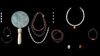 A collection of jewelry and other artifacts against a black background