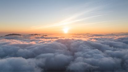 The sun rises above the clouds.