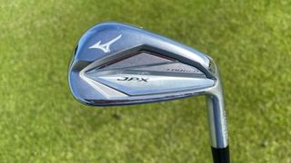 Mizuno JPX923 Forged Iron held aloft on the golf course