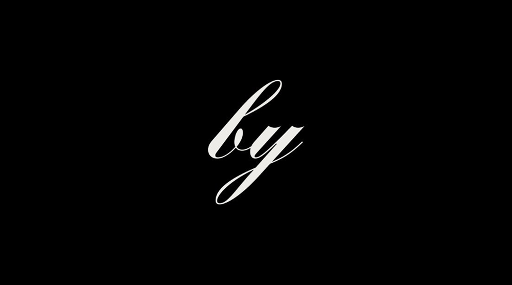America by Design logo shows the word 'by' in an italic handwriting font