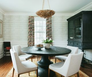 Black circular dining table with white chairs